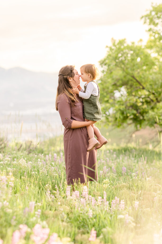 mom holding child during photos in flower field in utah