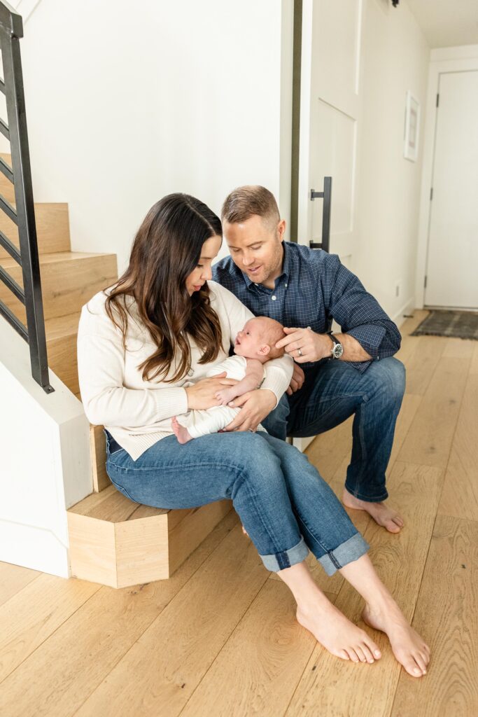 park city newborn photographer takes photo of family with newborn on stairs